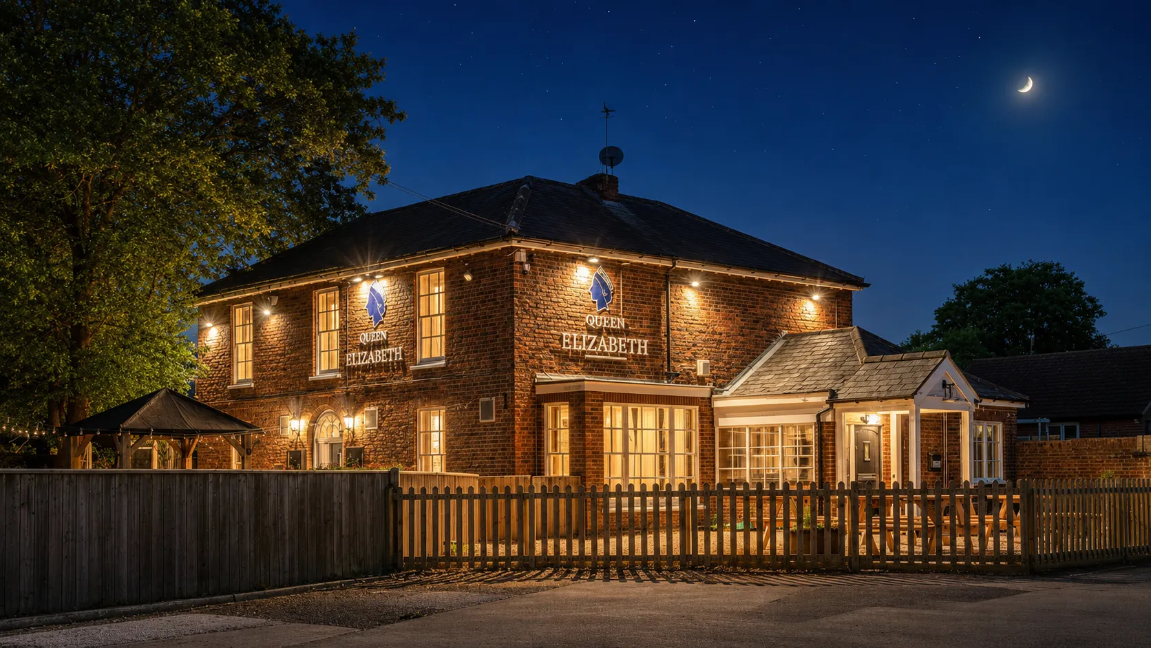The Queen Elizabeth pub exterior on Gayton Road, Gaywood, lit at night